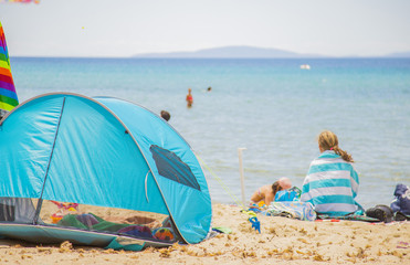 image of a beach tent with a person looking at the sea in the background