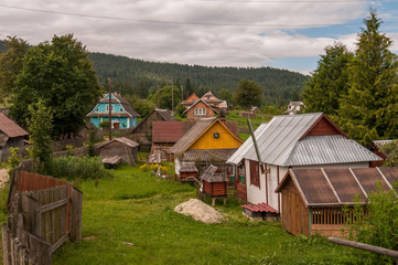 Fototapeta na wymiar View to the old Carpathian village with wooden houses near the hills