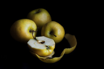 Bowl of yellow apples. On black background.