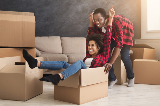 Young black couple unpacking moving boxes