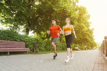 Fototapeta premium Athletic couple running together in park