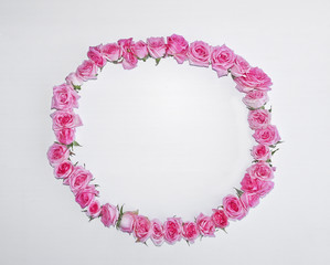 Vintage round frame of pink roses on a white background