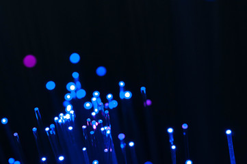 Blue abstract optical fibres close up macro shot on dark bluish background.