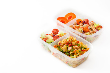 Healthy meal prep containers with pasta salad, vegetables, chickpea and fruit isolated on white background. Copyspace