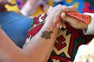 Mehndi (henna tattoo). A henna or mehendi applier at work