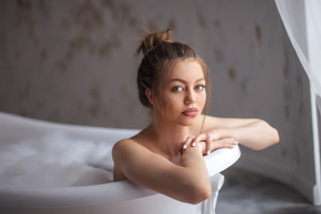 serious woman is using a tube in the bathroom