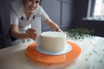 confectioner in a white apron on a dark background with a cupcake