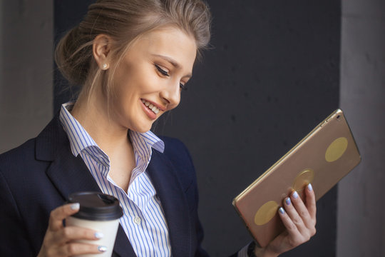 cheerful awesome girl with fair hair chtting online with friends while drinking coffee. closeup portrait