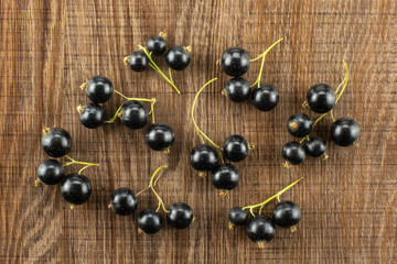 Fresh Raw Black Currant berry on brown wood