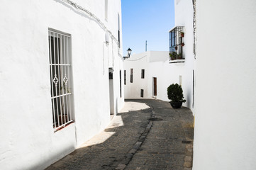 Narrow stone pavement street turning in Vejer white town on sunny day, Spain. Guided tour, summer holidays, travel destination concepts