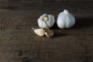 bulb of white garlic on back background and wood flour