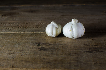 bulb of white garlic on back background and wood flour