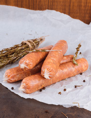 Raw sausages on a dark rustic metallic background. Meat sausages with spices on a baking paper. Copy space