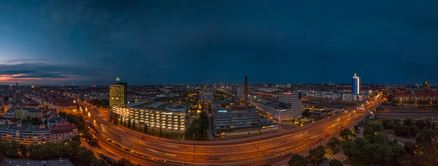 Blick über München und die Donnersberger Brücke am Abend, mit Lichtern über der von Autos befahrenen Straße im tollen Licht