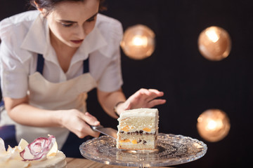 confectioner in a white apron on a pink background with a cake