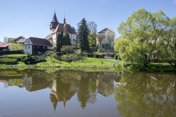 Fototapeta na wymiar Church of St. Wenceslas in town Svetla nad Sazavou, clock tower, greenery and blue sky, river Sazava