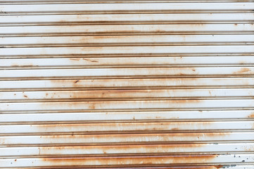 A closeup shot of automatic metal roller door used in factory, storage, garage, and industrial warehouse. The corrugated and foldable metal sheet offer space saving and provide urban and rustic feel