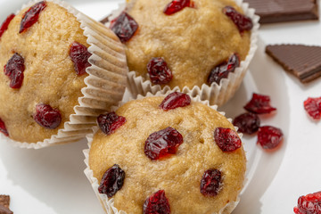 Homemade cupcakes with cherries are located on a light background. A few cupcakes are located on a white plate