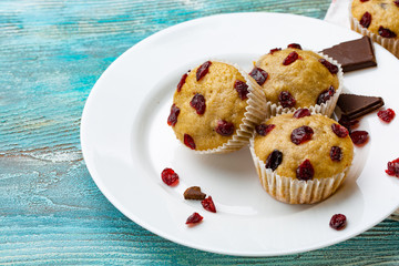 Homemade cupcakes with cherries are located on a light background. A few cupcakes are located on a white plate