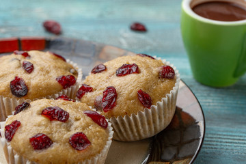 Homemade cupcakes with cherries are located on a light background. A few cupcakes are located on a plate