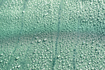 Rain drops on a turquoise textile surface