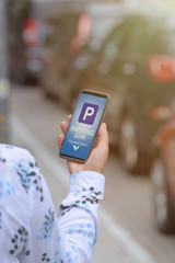 Woman using smartphone app to pay for parking