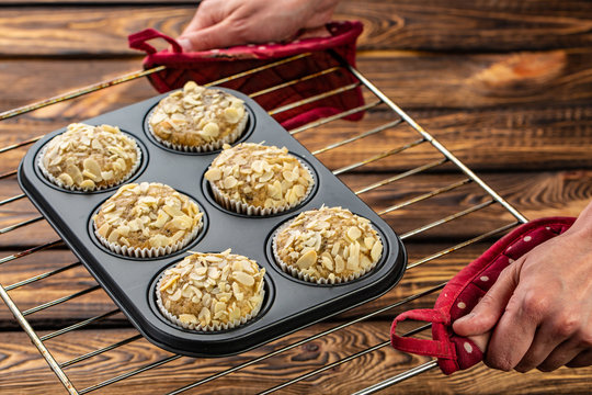 Carrot cupcakes with lemon and apple, almonds on wooden background, raw silicone form on a baking sheet