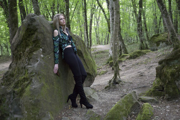 Naklejka na ściany i meble Fashion Model Girl on the Rock in the green summer forest