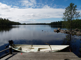 Naklejka premium Finnischer See an einem sonnigen Tag - Steg mit Boot