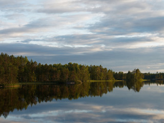 Fototapeta na wymiar Finnischer See an einem sonnigen Tag - mit Spiegelungen