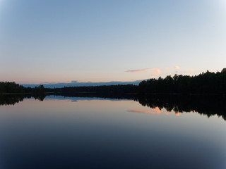 Obraz na płótnie Canvas Finnischer See an einem sonnigen Abend - mit Spiegelungen