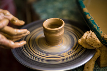 Sculpts in clay pot closeup. Modeling clay close-up. Caucasian man making vessel daytime of white clay in fast moving circle. Art, creativity. Ukraine, cultural traditions. Hobbies