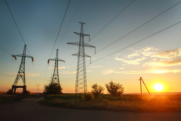 High electricity power line towers at dramatic sunset