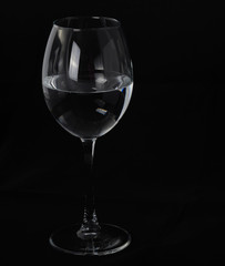one transparent glass with a drink long leg on a black backgroun