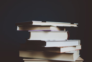 Tower of colorful books on the table. Closeup of pages. Abstract concept of knowledge, education, learning, and literature. Filter