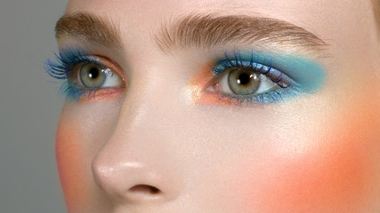 Bright creative make-up of eyes with long eyelashes. Blue color of eyes, pink blush on a brilliant...