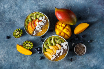 Mango smoothie bowl with kiwi, peach and chia. Healthy vegan diet breakfast concept.