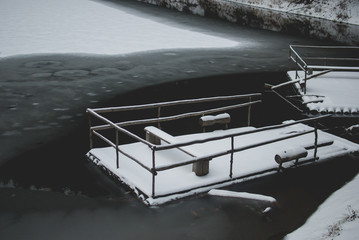 Wooden raft on the frozen winter lake