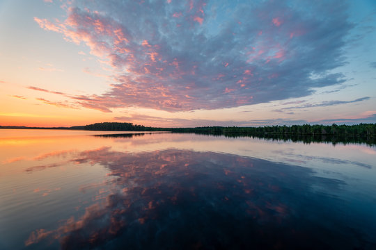 Very beautiful landscape image of a sunset behind calm mirror clear lake