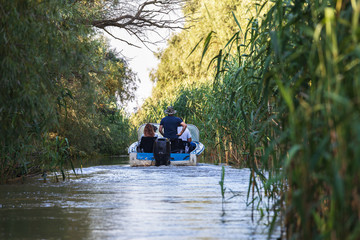 Tourists enjoying the Romanian beautiful Danube delta. Group of people on a boat trip in the Danube Delta Biosphere Reserve. Danube delta is the second largest river delta in Europe.