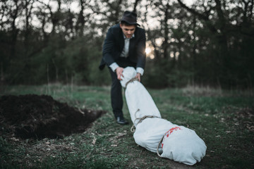 Slayer drags the victim's body into a grave
