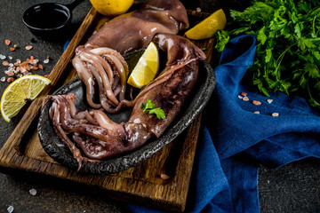 Fresh raw seafood, squid with lemon and light for preparation on a light blue background
