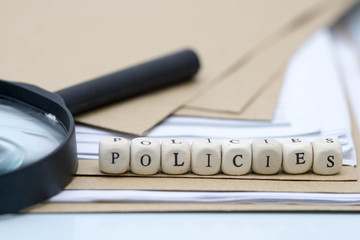 The concept of policies. Words use blocks of wood on files and documents. Selective Focus.