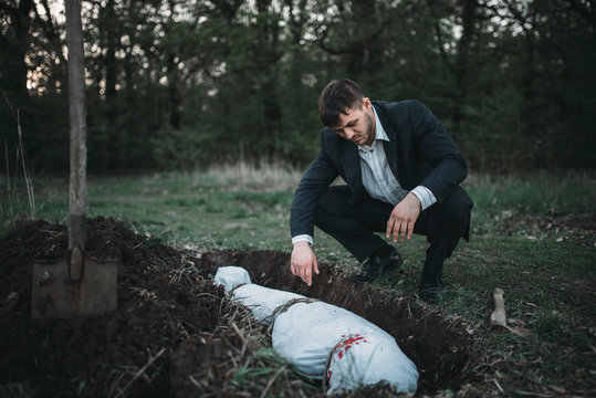 Maniac against grave, serial murderer concept