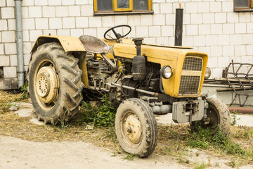 An old tractor produced in the 70s of the 20th century. General view of the agricultural machine. The necessary equipment for a dairy farm.