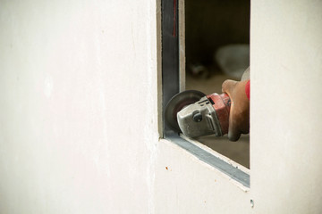 Worker using machine angle grinders at window edge cement board. To keep the details wrinkle damage to be neat. and copy space.