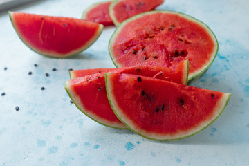 Fresh organic watermelon sliced on light blue bakground. Selective focus