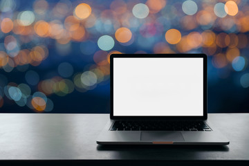 Conceptual workspace, Laptop computer with blank white screen on table, blurred background.                     