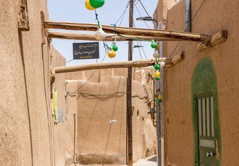 Decorations somewhere on the narrow streets of old town in Yazd, Iran. Persian or Arabic style of architecture. Sign says "Khorram is from Kabir to Khane, our head is dasha Habfar"