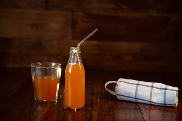 vintage bottle with juice, straw and towel on wooden table